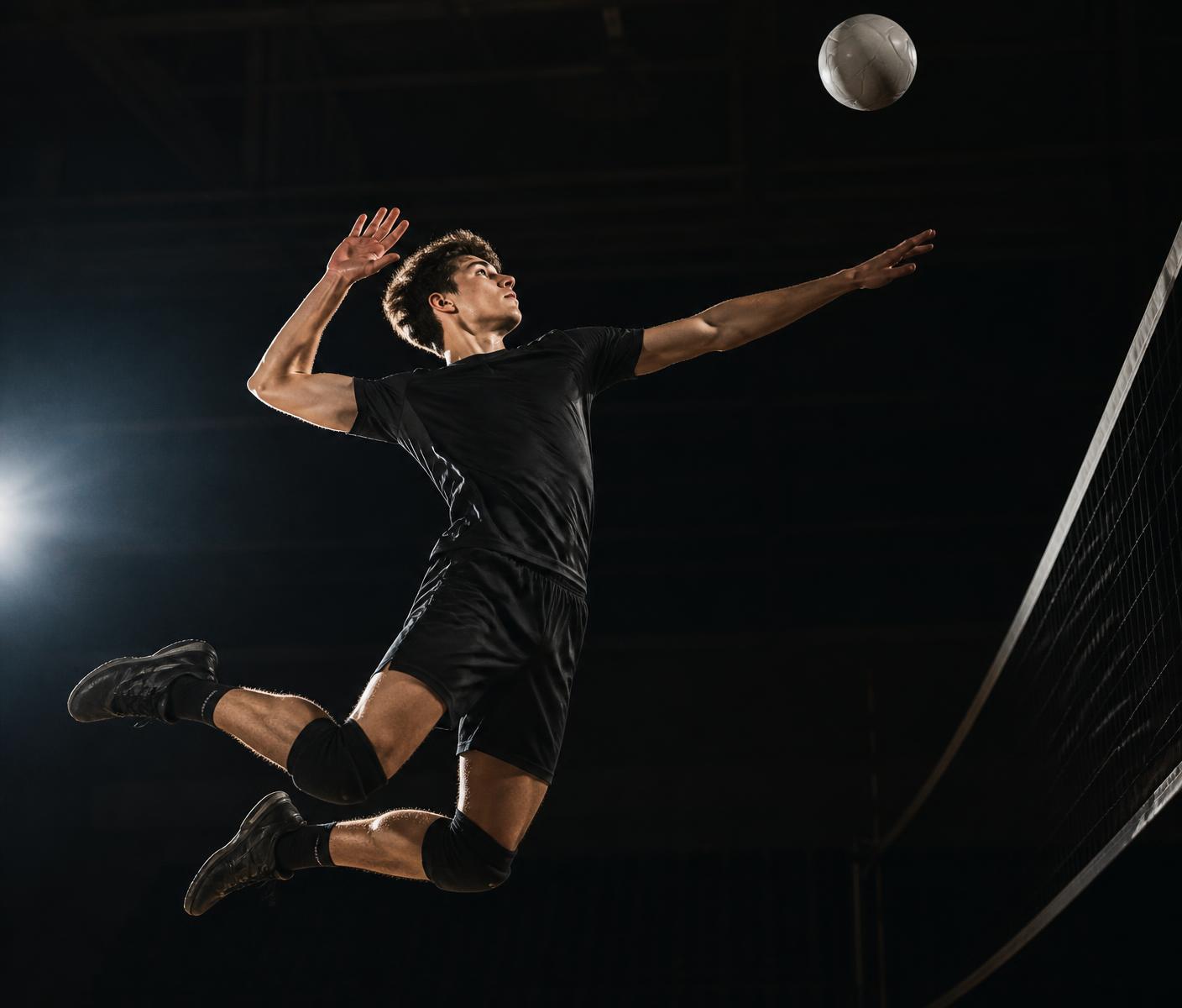 Volleyball attacker swinging at the ball in a dark gym